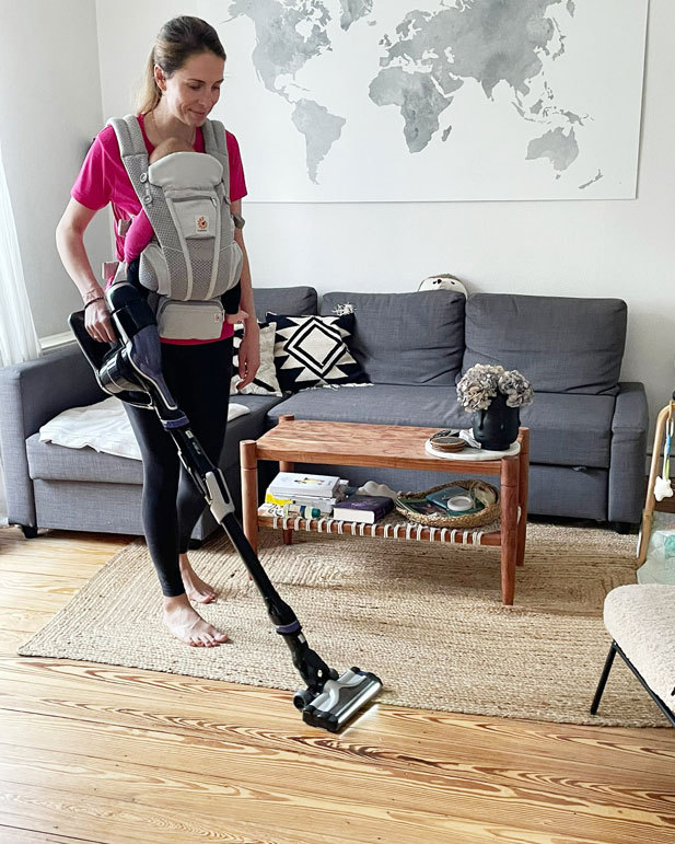 Une femme nettoie un canapé avec un aspirateur photo – Rangement