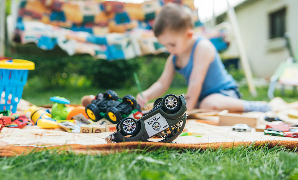 enfant jouant dans le jardin avec ses jouets