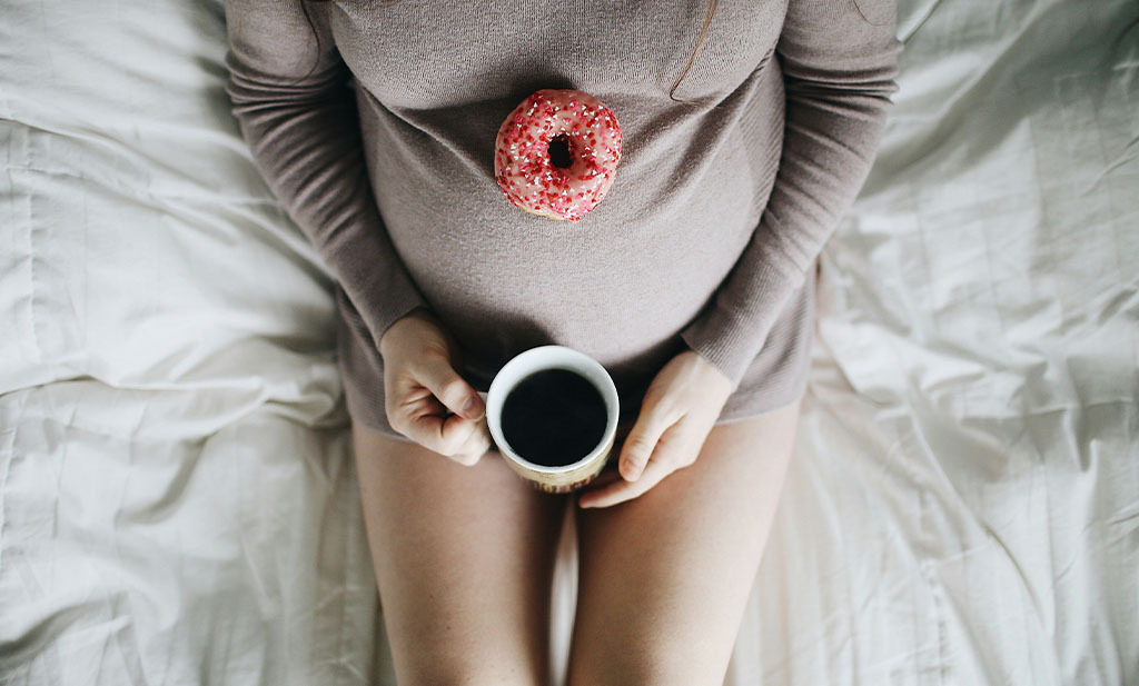 Femme enceinte tenant une tasse de café 