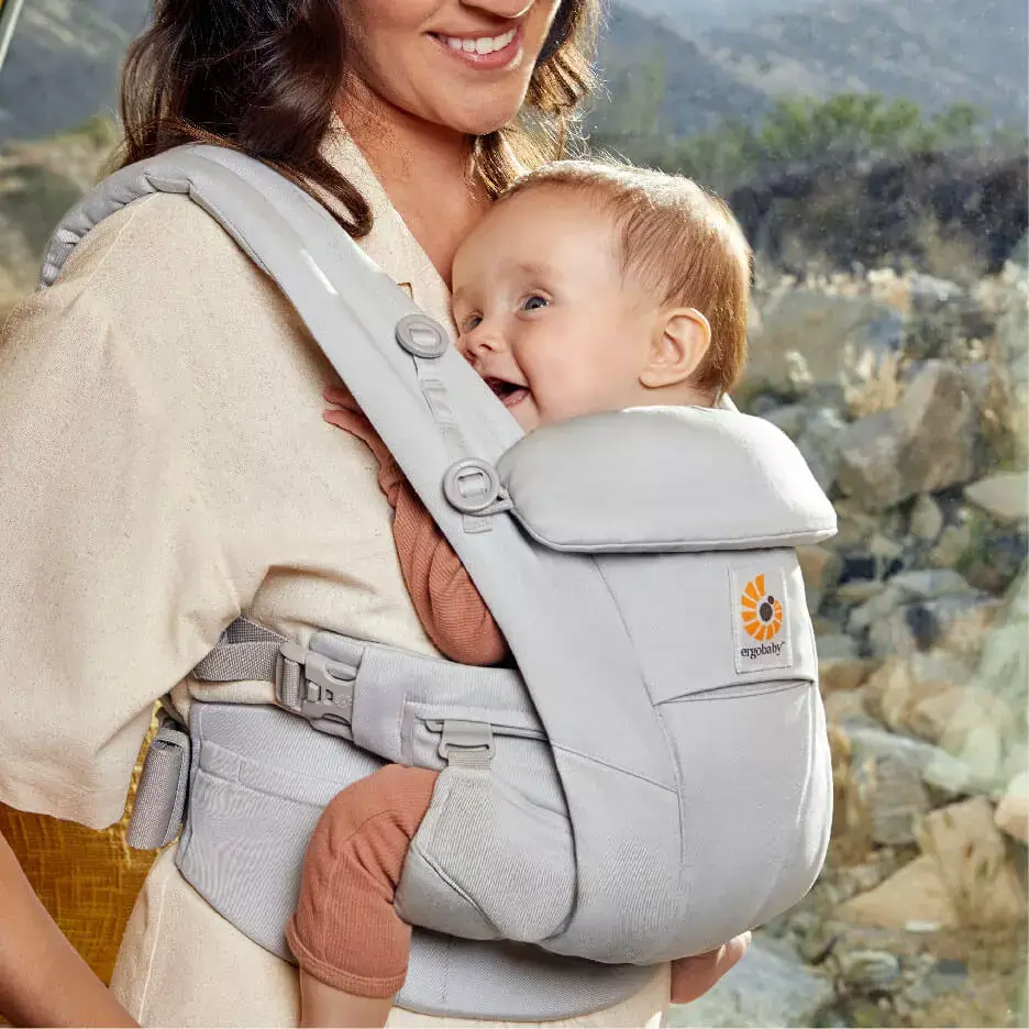 mère portant son enfant dans un porte-bébé Omni Dream